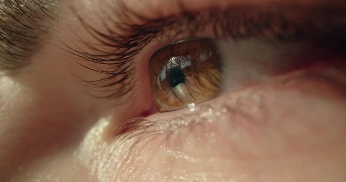 Super macro shot of a woman opening her brown eyes. Slow motion video. High quality 4k footage