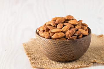 Raw peeled almonds in brown bowl