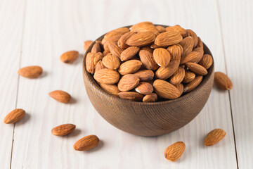 Raw peeled almonds in brown bowl
