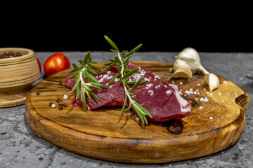 Fresh raw beef steaks on a wooden board
