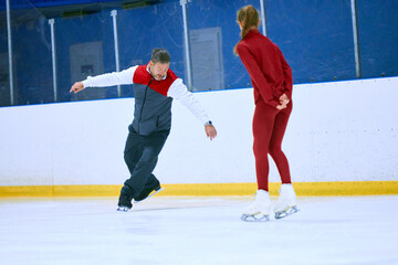Professional skater, man training girl, learning figure skating activity on ice rink arena. Sport lessons with coach. Concept of professional sport, competition, sport school, health, hobby, ad