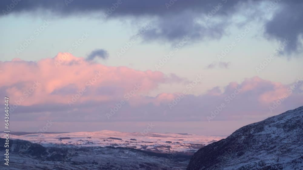 Wall mural Dawn weather with pink light on snowy British mountains