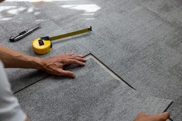 worker installing carpet tiles on the floor - 643644463