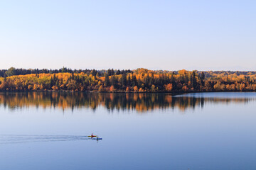 People kayaking in Glenmore Reservoir on a clear Autumnal morning