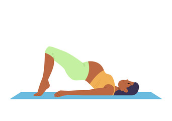 Healthy active pregnant woman in sportswear doing yoga standing in bridge pose on floor exercise mat