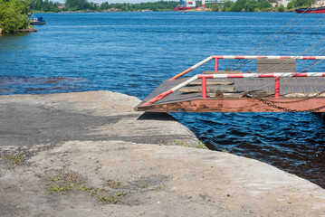 the ladder of the ferry crossing for the descent of vehicles, crossing on a full-flowing river...