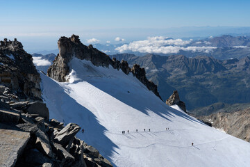 Fototapeta na wymiar Mountaineers climbing Gran Paradiso glacier to the summit of the mountain. Gran Paradiso National Park, Italian Alps.