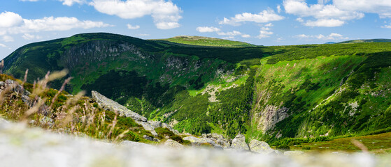 Giant Mountains, mountain panorama from the hiking trail to the top of Sniezka. View of the vast mountain slopes and trails on a sunny summer day. - obrazy, fototapety, plakaty