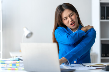 Young businesswoman having pain and fatigue in her shoulders and neck from stretching. Relax caused...