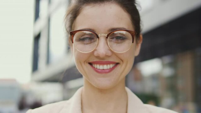 Pretty young woman in eyeglasses sincerely laughing with healthy toothy smile looking at camera, positivity, good mood and wellness