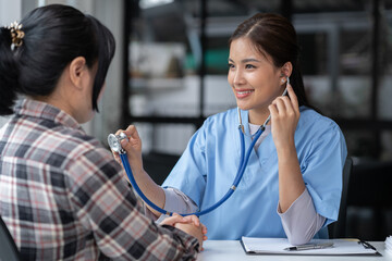 Asian female doctor using a stethoscope to examine a patient, ask for information, give advice,...