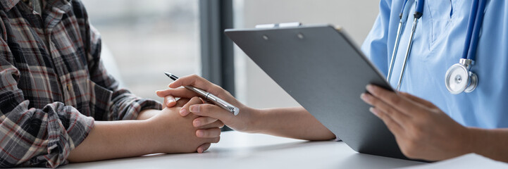 Asian female doctor using a stethoscope to examine a patient, ask for information, give advice,...