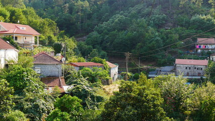 Fototapeta na wymiar Village hispanique sur le flanc d'une montagne, village en pierre de montagnes, sur le sommet d'une montagne, dans un vaste environnement de nature et de verdure, perché, coin tranquille, balade