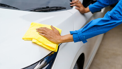 Man cleaning the car with a clean cloth, washing the car, wiping the car, polishing the car, wiping dust