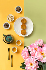 Flat lay Mid-autumn festival food and drinks - mooncake and tea set on light colour background.