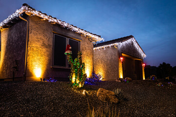 A home decorated with Christmas Lights with a dramatic evening sky in the background.
