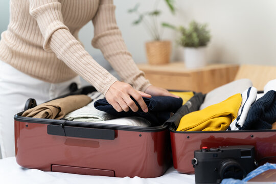 people packing outfit to suitcase for vacation trip