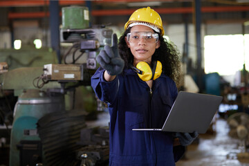 factory worker or technician holding laptop computer and pointing pose in lathe factory
