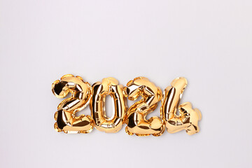 2024 golden air balloons on a blue background with copy space. New Year minimal composition.