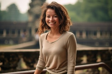 Lifestyle portrait photography of a grinning girl in her 30s wearing a long-sleeved thermal undershirt at the angkor wat in siem reap cambodia. With generative AI technology