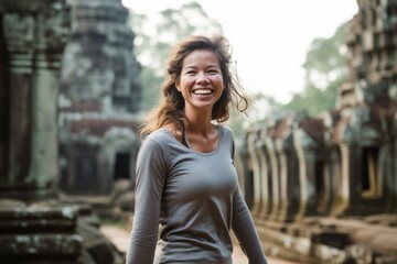 Fototapeta premium Lifestyle portrait photography of a grinning girl in her 30s wearing a long-sleeved thermal undershirt at the angkor wat in siem reap cambodia. With generative AI technology
