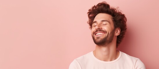 Obraz premium Happy man with hands behind head smiling on pink background