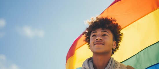 Digital image of a confident biracial man celebrating national coming out day by waving a rainbow flag copy space for lgbt awareness and support of the queer community