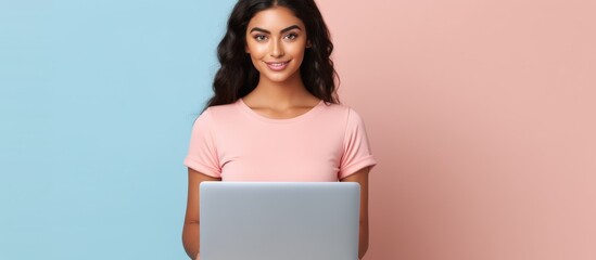 Young blonde woman in her 20s wearing a casual pink t shirt working on a laptop computer