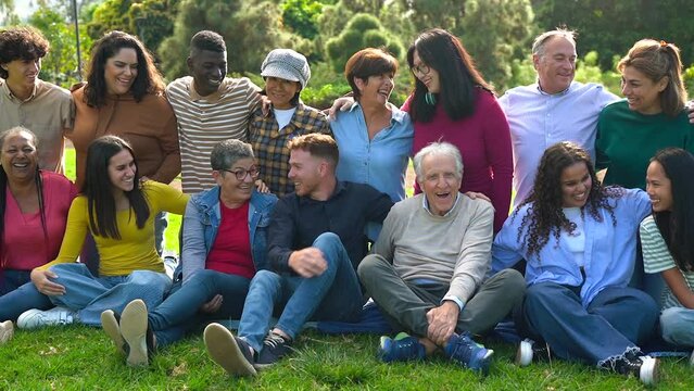 Group of multi generational people having fun together outdoor - Multiracial friends enjoy day at city park - Community and inclusion concept
