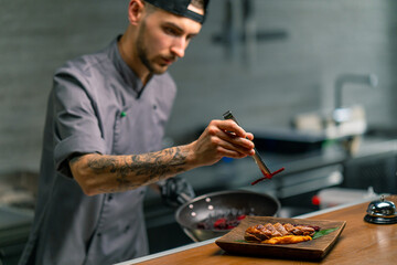 Professional kitchen in the restaurant the chef lays out delicious fried duck breast and puree on a...
