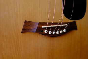close-up wooden part of the instrument, changing strings on acoustic guitar, strings hanging...