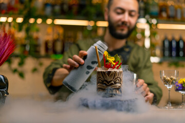 professional bartender pours near fresh alcoholic delicious cocktail liquid nitrogen beautiful and...