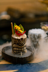 fresh alcoholic tasty cocktail stands on the bar near which liquid nitrogen spreads beautiful and effective serving of the drink in a bar