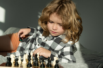 Clever thinking child. Child think about chess game. Intelligent, smart and clever school kid...