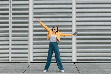 excited woman with joy in the street with mobile phone