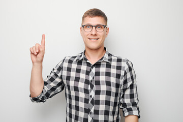 Portrait of clever man in shirt raises finger have idea isolated on white studio background with copy space. Confidence smart genius