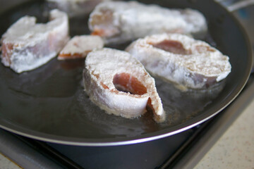 Floured and cooked salmon in a pan, making flour fish, cooking salmon in a pan,