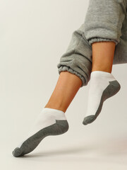 white and gray socks with copy space on human feet close up photo on white background