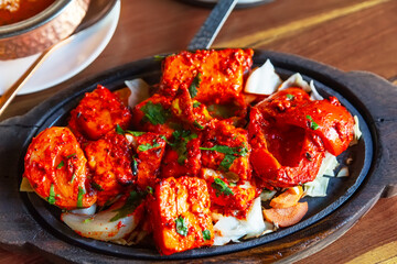 Tandoori Paneer Tikka. Cubes of cottage cheese, tomatoes, bell peppers and onion finished in clay...
