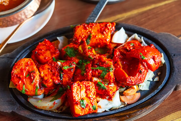 Tandoori Paneer Tikka. Cubes of cottage cheese, tomatoes, bell peppers and onion finished in clay oven.