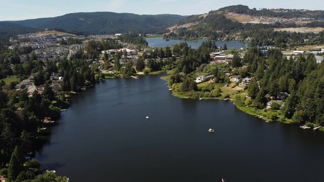 Aerial Glen Lake and Langford Lake parallax shot overlooking distant development near Bear Mountain in Victoria BC Canada.
