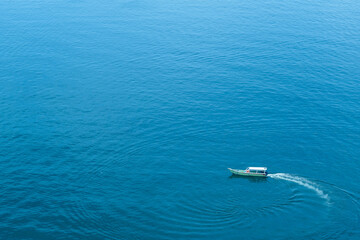 Fishing boat traveling in the beautiful blue sea. Fishing boat spinning