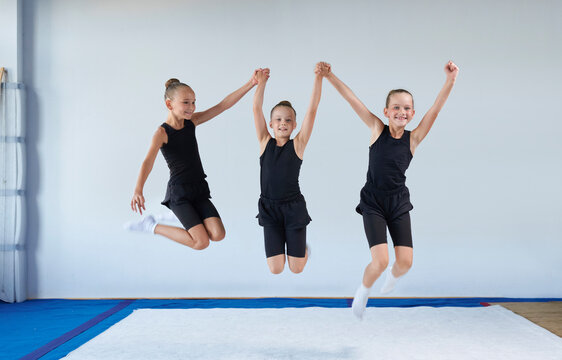 Group of cheerful children are jumping in the gym. Gymnastics concept.