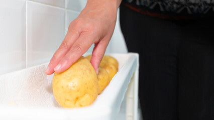 cook selecting a potato from the greengrocer to cook a balanced diet. Healthy natural food