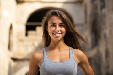 Medium shot portrait photography of a grinning girl in his 20s wearing a stylish sports bra at the crac des chevaliers in homs governorate syria. With generative AI technology