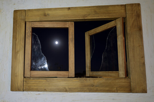 luna llena atreves de la vieja ventana con los cristales rotos