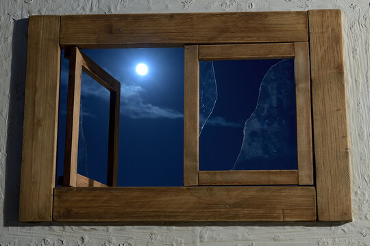 luna llena atreves de la vieja ventana con los cristales rotos
