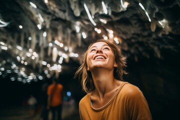 Medium shot portrait photography of a joyful girl in his 30s wearing a trendy cropped top at the waitomo glowworm caves in waikato new zealand. With generative AI technology