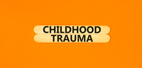 Childhood trauma symbol. Concept words Childhood trauma on beautiful wooden stick. Beautiful orange...