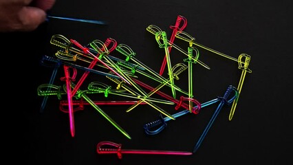 Taking cocktail sticks on black background time lapse